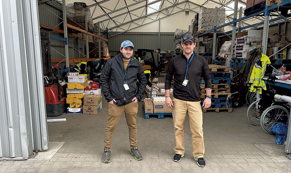 Colin Hilliard and Adam Roof at a warehouse in Medyka filled with food purchased with Vermont dollars - COURTESY