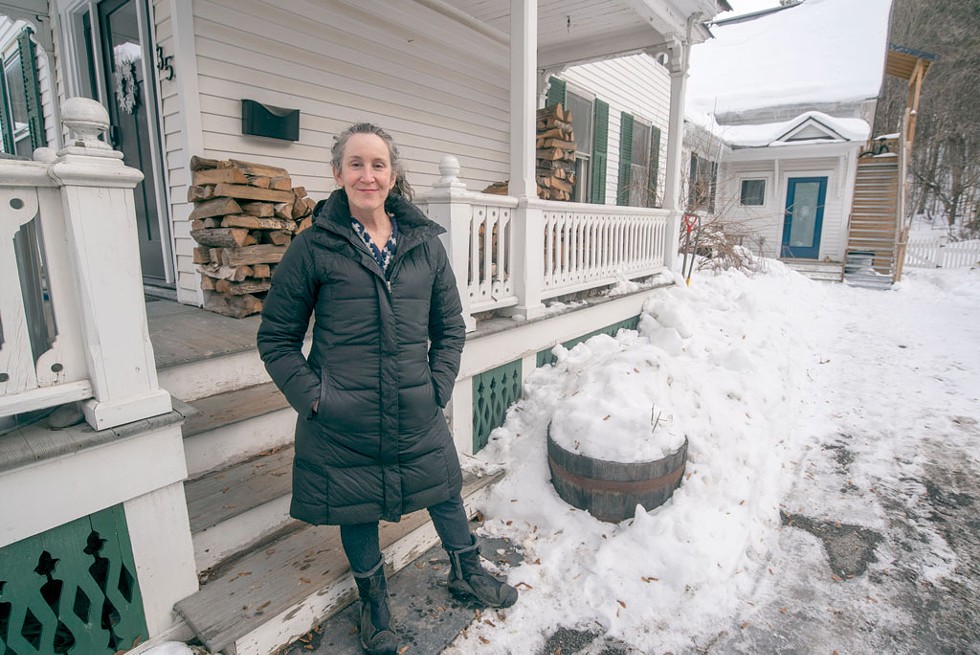 Marni Leikin in front of her Montpelier home. She built a one-bedroom ADU above the carriage barn in her backyard (see background). - JEB WALLACE-BRODEUR