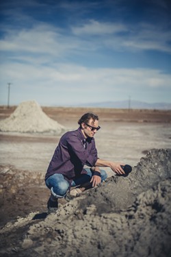 Sam Harnett interviewing a mud pot - GUNDI VIGFUSSON