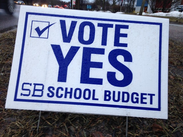 Sign urging voters to approve the budget - MOLLY WALSH
