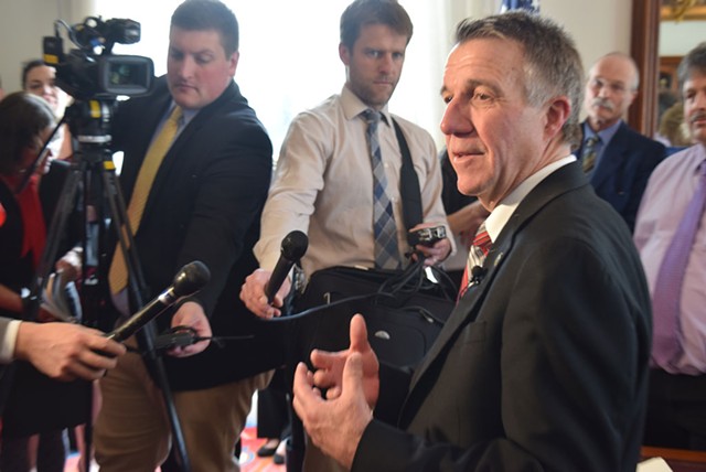 Gov. Phil Scott discusses health care negotiations with reporters Friday in his Statehouse office. - TERRI HALLENBECK