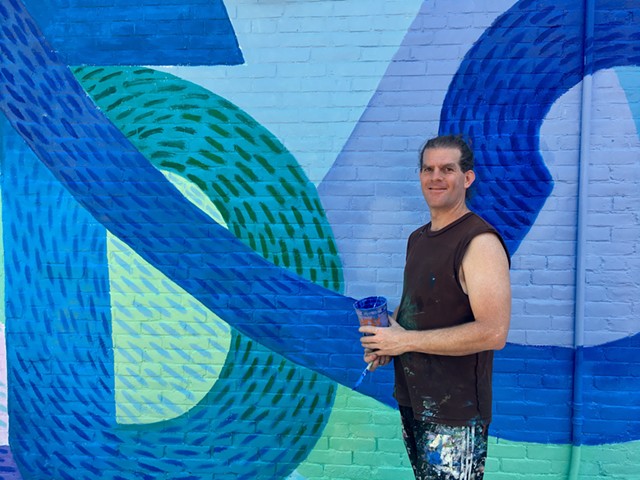 Alex Cook in front of his Cherry St. mural. - SADIE WILLIAMS