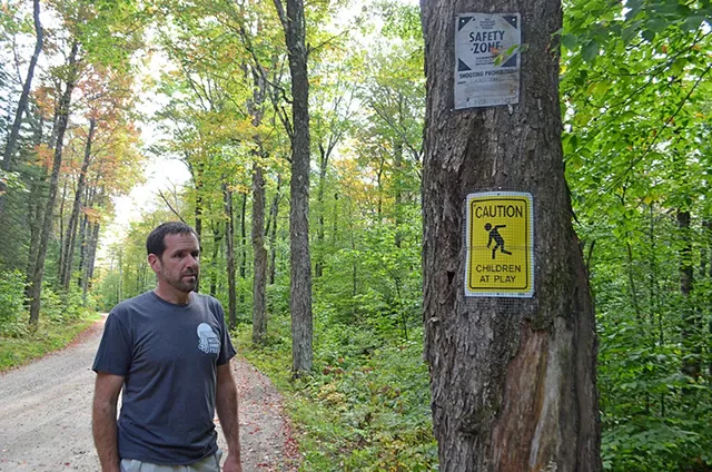 Chris Pike standing near signs he posted - MOLLY WALSH
