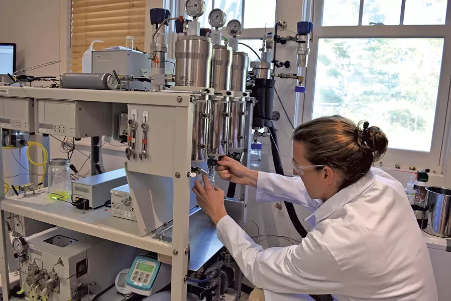 Eric Kawka working with cannabis-testing equipment - TERRI HALLENBECK