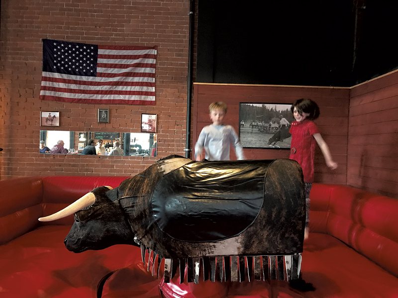 Reaney McKinley, 9, and Della Connor, 7, play in Rough Cuts mechanical bull ring - SALLY POLLAK
