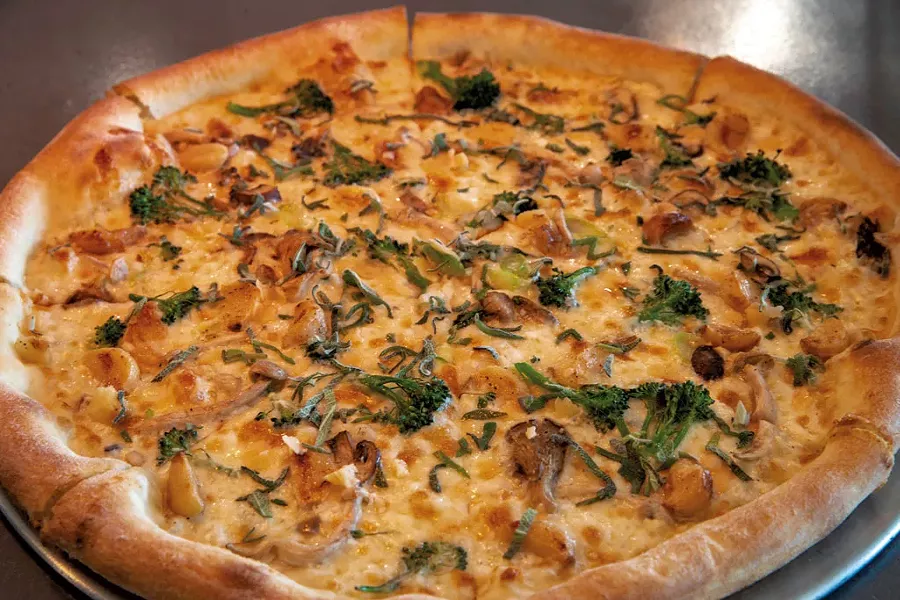 Forager pizza with house white sauce, mushroom blend, broccolini, roasted garlic and shaved Asiago - JAMES BUCK
