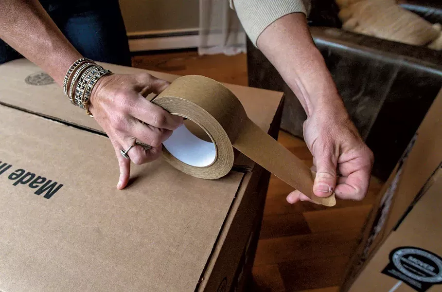 Marlene Simson packing a moving box - GLENN RUSSELL