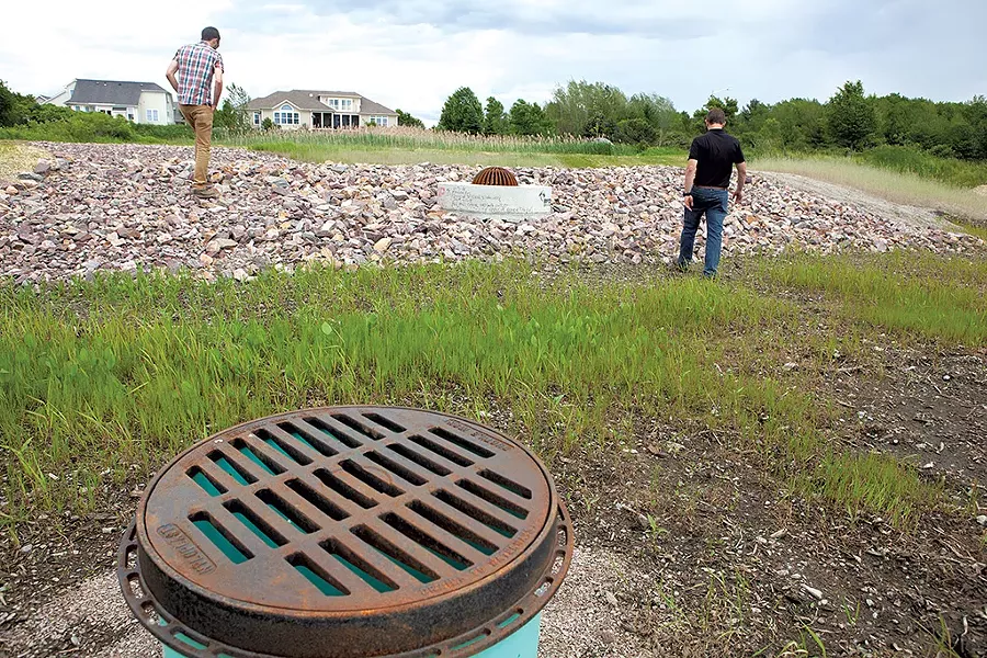 David Wheeler (left) and Tom DiPietro touring a rebuilt stormwater pond at the Pinnacle at Spear neighborhood - KEVIN MCCALLUM