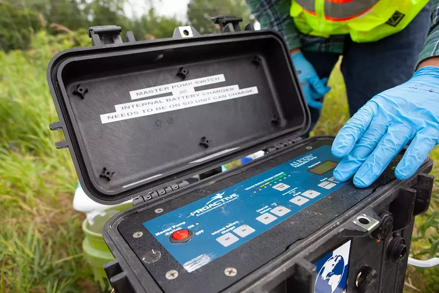 Aaron Sutton tests a well outside the Air National Guard base in Burlington last week. Sutton works for Parsons Corp., the environmental firm performing a range of tests to see if contamination on the base has migrated toward the Winooski River. - KEVIN MCCALLUM