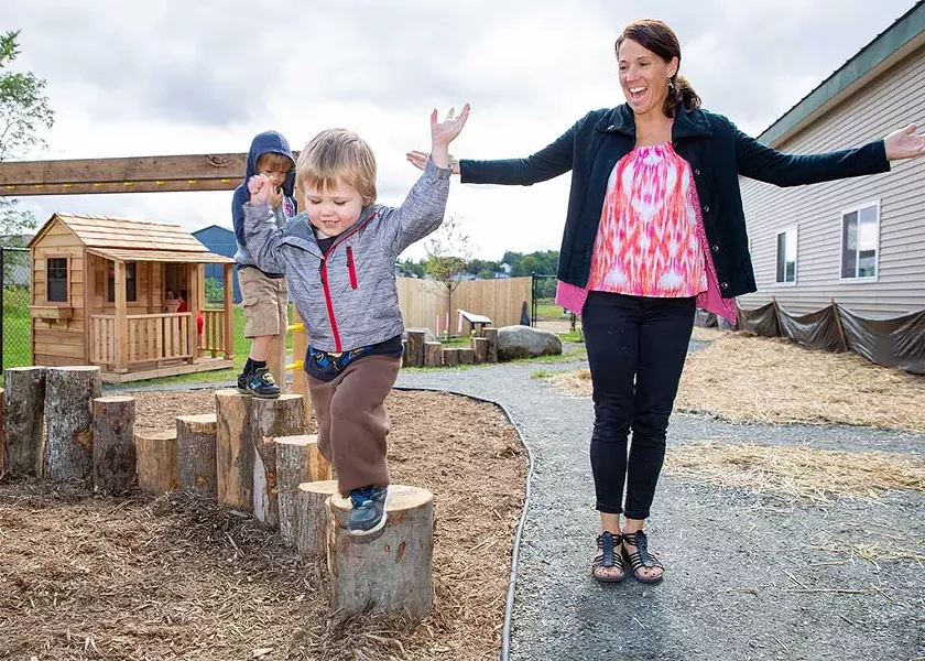 Adonis and Moses try out the balance logs with Michelle Jenne on the Newport Early Childhood Center playground. - WAYNE TARR