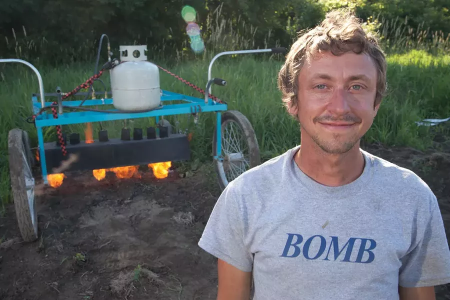 Rob Rock, co-owner of Pitchfork Farms with his flame weeder - MATTHEW THORSEN