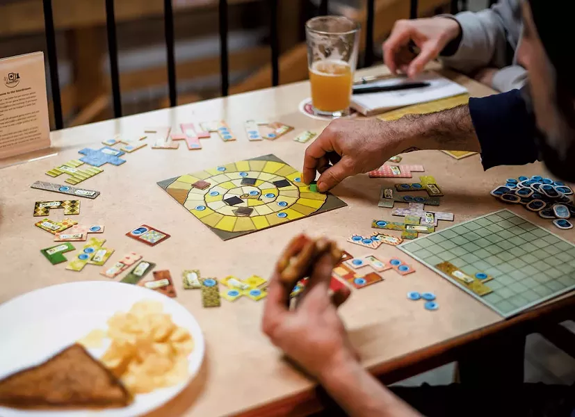 Playing Patchwork at the Boardroom Café - GLENN RUSSELL