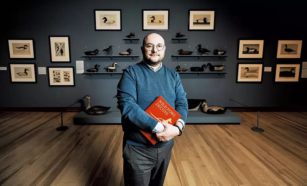 Kory Rogers standing in front of the "Joel Barber & the Modern Decoy" exhibit - BEAR CIERI
