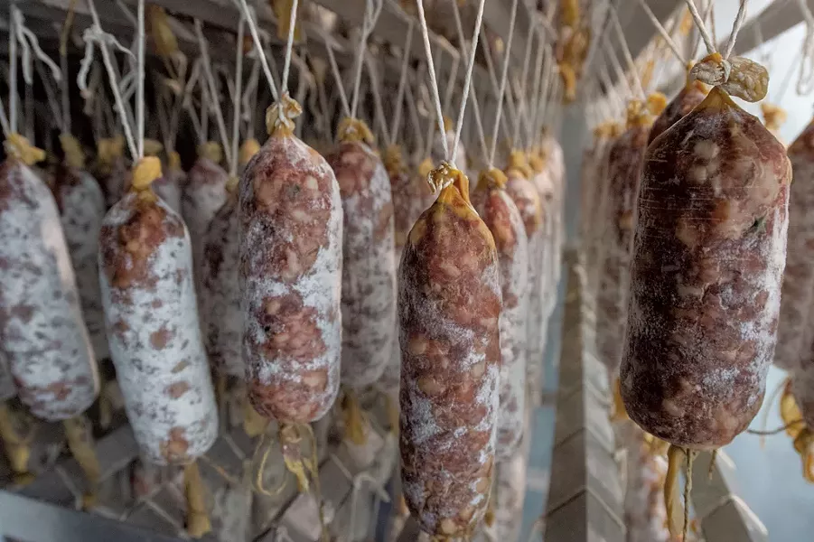 Racks of aging Babette's Table salamis - JEB WALLACE-BRODEUR