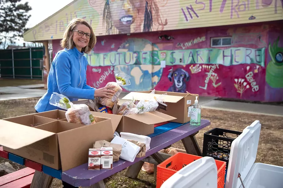 Tanya Benosky handing out food to kids in the Old North End’s Roosevelt Park - JAMES BUCK