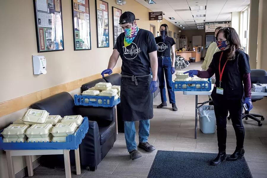 Andrew Ryan and Maddy McKenna delivering meals to Joanne Wallis (right) at the Community Health Centers of Burlington - LUKE AWTRY