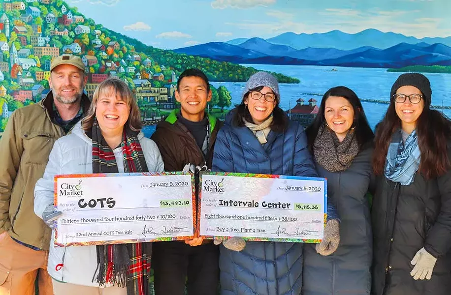 Staff members presenting donation checks to the Committee on Temporary Shelter and the Intervale Center - COURTESY PHOTO