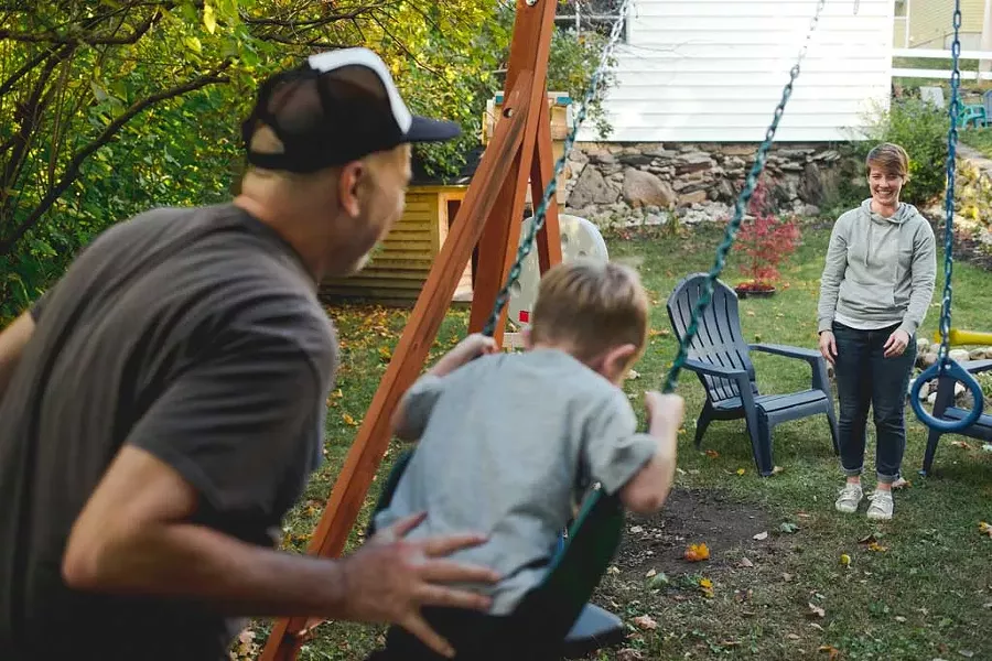 Maresa Nielson and her husband swinging with one of their foster sons - SARAH PRIESTAP
