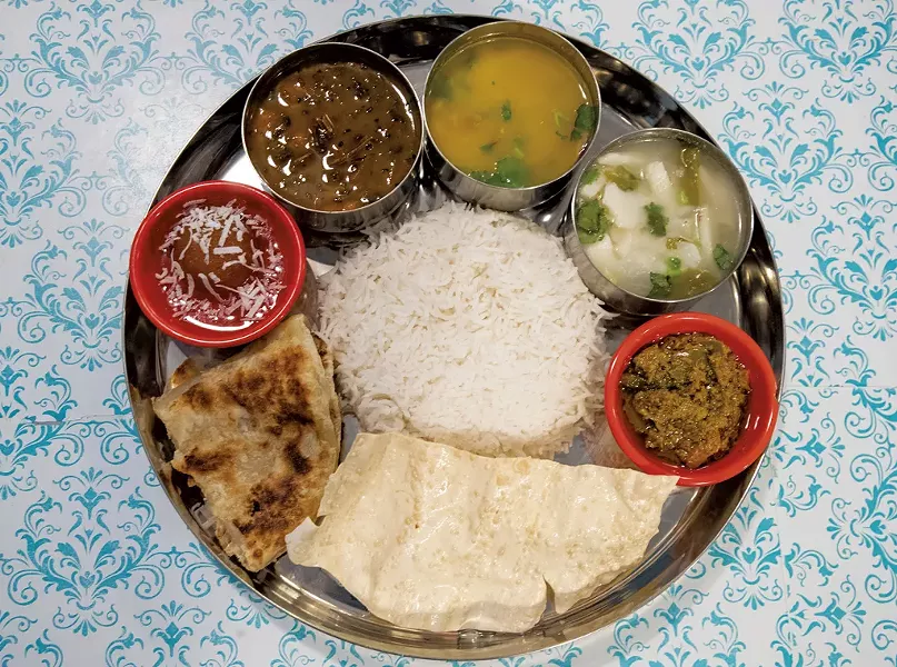 House special thali (clockwise from top left): gundruk soup, lentil soup, ema datshi, mango chutney, two breads, gulab jamun and rice from Friend's Nepali Restaurant - JAMES BUCK