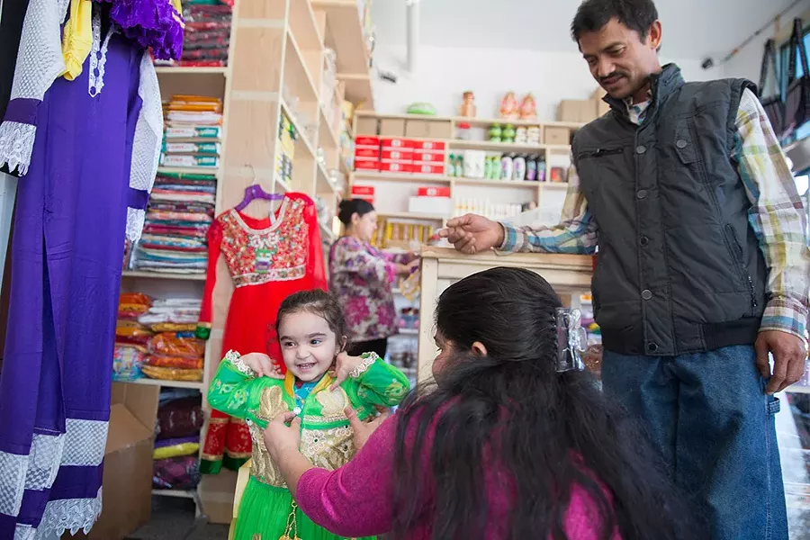 Lal Maidali looks on as a young customer tries on a dress - JAMES BUCK