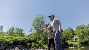 Guide Stephanie Olsen giving fly-fishing instruction in Stowe