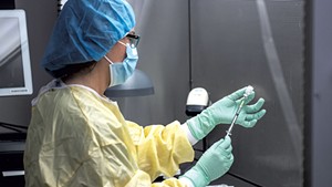 A health care worker preparing a dose of COVID-19 vaccine