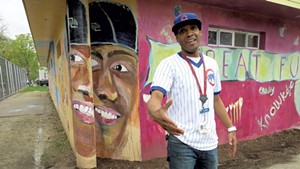 Barrino in front of his portrait on the mural in Roosevelt Park