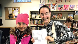 Mira gives a painted tote bag and note to our children's librarian
