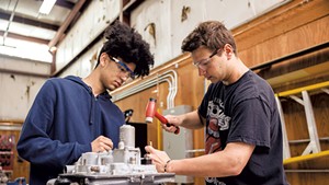 Victor Colon (left) and Austin Daigneault disassembling a plane engine at the Burlington Technical Center