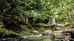 Jamie Eisenberg fly-fishing at a creek in Underhill