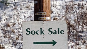 A sign pointing the way to a Darn Tough sock sale in the past.