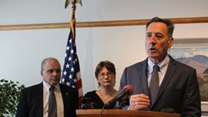 Chief of health care reform Lawrence Miller and director of health care reform Robin Lunge, center, watch as Gov. Peter Shumlin speaks.
