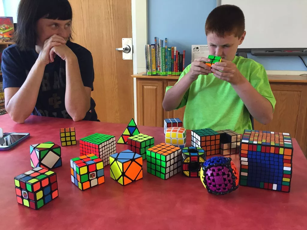 Brady solves a puzzle while his mom looks on