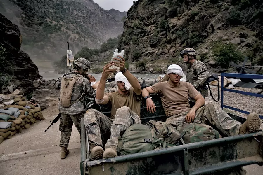 Wounded U.S. Army soldiers await evacuation by helicopter from Kamdesh, Nuristan province. - COURTESY OF ROBERT NICKELSBERG