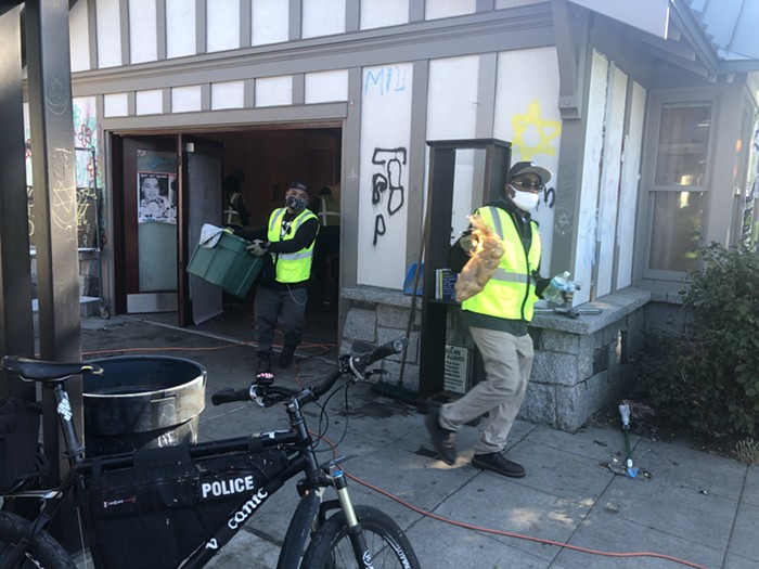 Seattle Parks crews dumping food and supplies for the homeless into their dump truck.