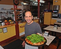 Michael Calogerakis shows the white pizza with arugula, lemon oil, ricotta and mozzarella at his Church Hill business, Anthony's on the Hill.