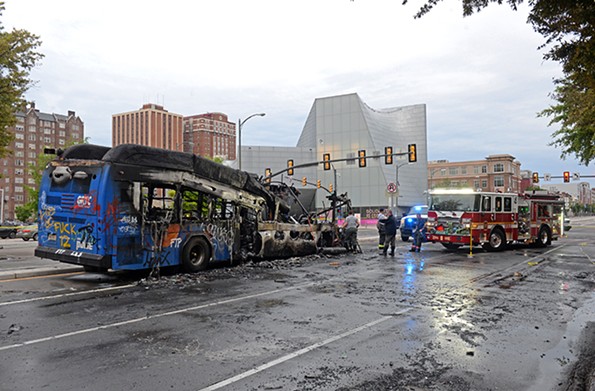 Richmond firefighters examine a burned out GRTC bus at Belvidere and Broad streets early Saturday. The bus was set on fire late Friday, May 29. - SCOTT ELMQUIST