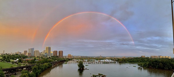 A beautiful double rainbow sweeps over the city.