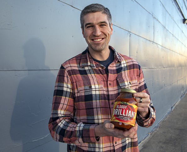 Will Gray, founder and CEO of Back Pocket Provisions, holds a jar of his classic Bloody Brilliant Bloody Mary mix. - SCOTT ELMQUIST