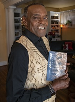 Branch holds up his recent book of poetry, "Juju Jazz Poetics." - SCOTT ELMQUIST