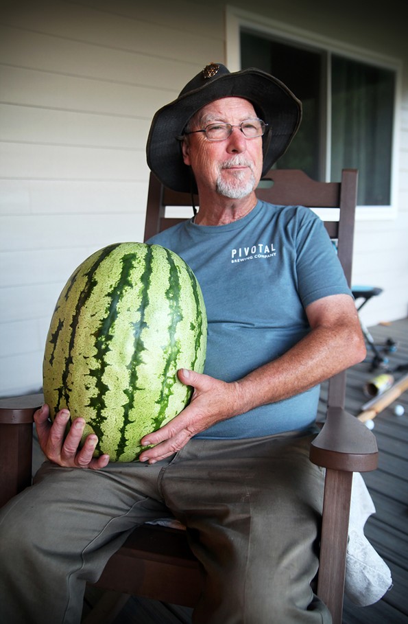 Anthony Fitzwater, 70, in 2022 sitting with a Red-N-Sweet heirloom watermelon in Halifax, Va. that he and his son Joshua grew to commercially reintroduce the melon to growers and farmers.