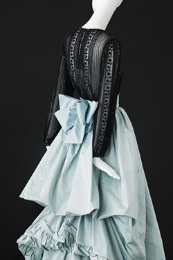 A blue silk taffeta gown with train and white silk taffeta flounces, trimmed with black braiding from the spring-summer 1981 haute couture collection of Yves Saint Laurent. - ALEXANDRE GUIRKINGER