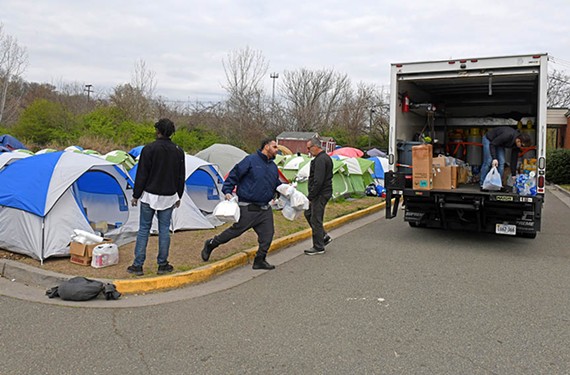 Volunteers from Blessing Warriors load trucks with supplies on March 18, the day Camp Cathy was dismantled.