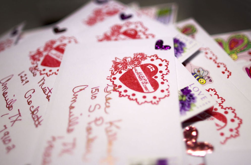 Postmaster Kathryn Fajna marks each Valentine she receives with a red heart cachet for Valentines Day. - BILL TIERNAN