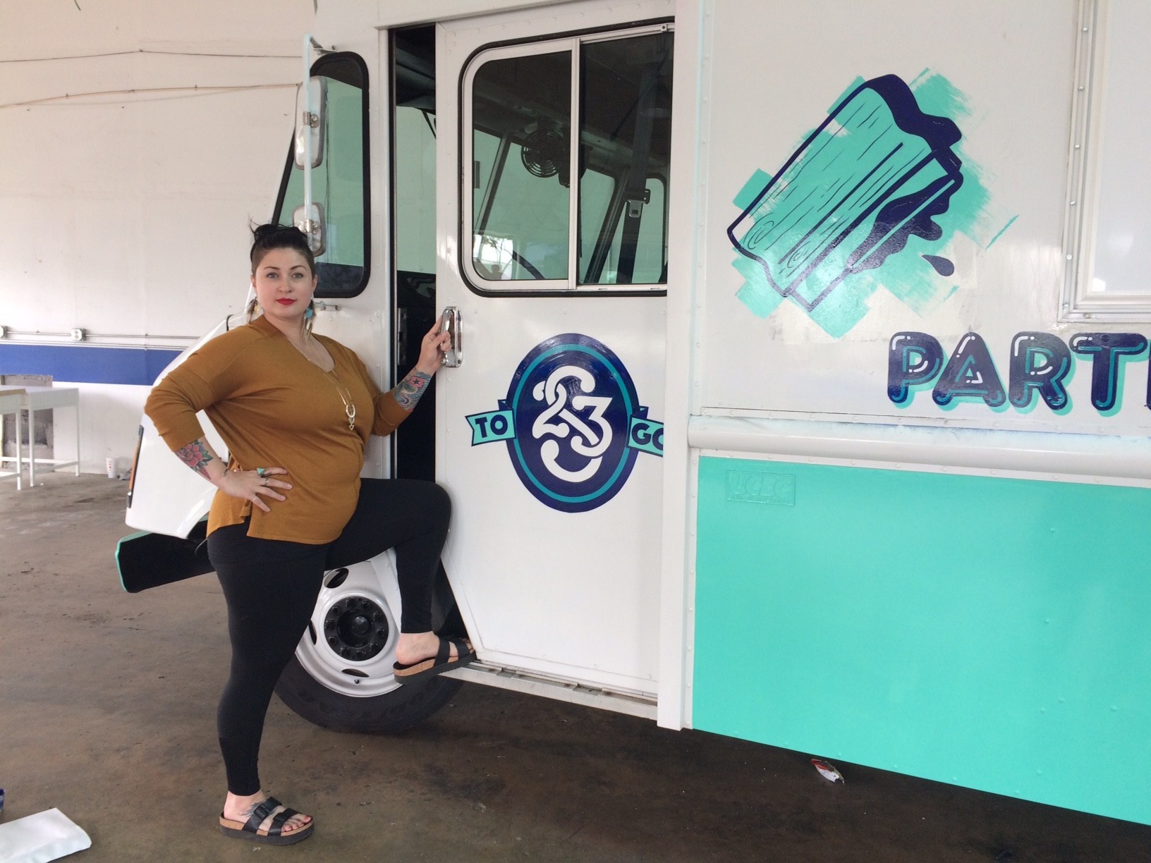 Recent Style Weekly Women in the Arts honoree, Ashley Hawkins stands next to Studio Two Three's new mobile studio.