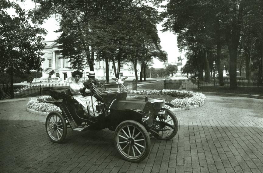William Mann Jr., son of Gov. William Hodges Mann, lets a friend take the wheel of a Model T Ford in the mansion driveway (c. 1910). The Capitol, at left, and Washington Monument are in the distance. - LIBRARY OF VIRGINIA