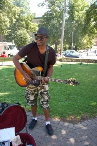 Dammien, who had just finished a busking session at the Farmers' Market, looks for cool comfort when performing: "I don't want to go down in leather," he laughs. We like his new kicks, and the glimpse of the camouflage bandana peeking out from under his hat, which he recently bought in Toronto, when performing in Dundas Square.