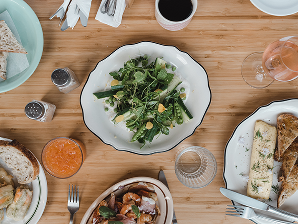 Clockwise from left: Adamski’s zucchini blossom poppers, cucumber and peashoot salad with garam masala yogurt, classic three-fold French omelette with gruyere and herbs (and Birdie’s Bread Co. sourdough) and shrimp toast. - ALEXA CUDE