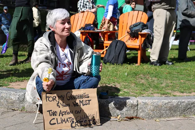 Kelly Daphne sits on the ground before the rally. She is attending to support a future for her grandchildren. - ISABEL BUCKMASTER