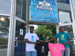 Marvin Okello and Birt Beal show off a t-shirt outside the Quinpool Road Wanderers store. - HFX WANDERERS FC
